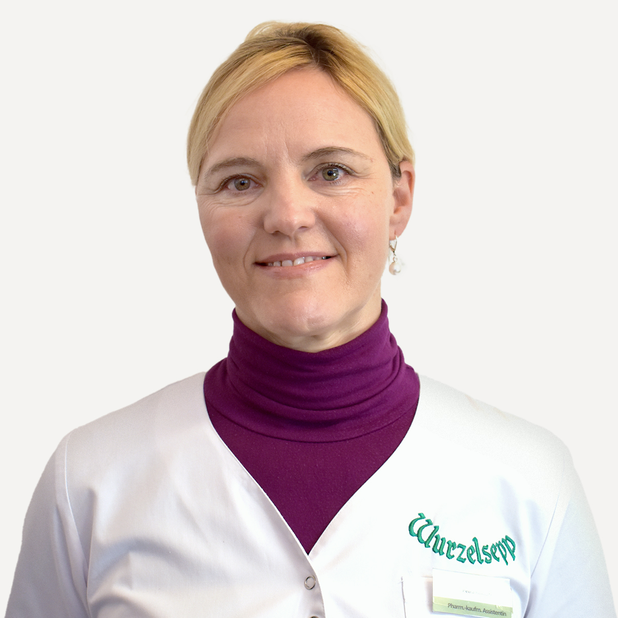Der Mitarbeiter Petra Rothütl m weißen Apothekermantel.