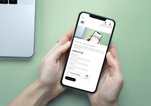 Hände halten ein Smartphone mit der geöffneten Website der Wurzelsepp. Auf dem Bildschirm ist das Eingabeformular zur Newsletter-Anmeldung mit den Feldern „Vorname“, „Nachname“ und „E-Mail“ zu sehen.